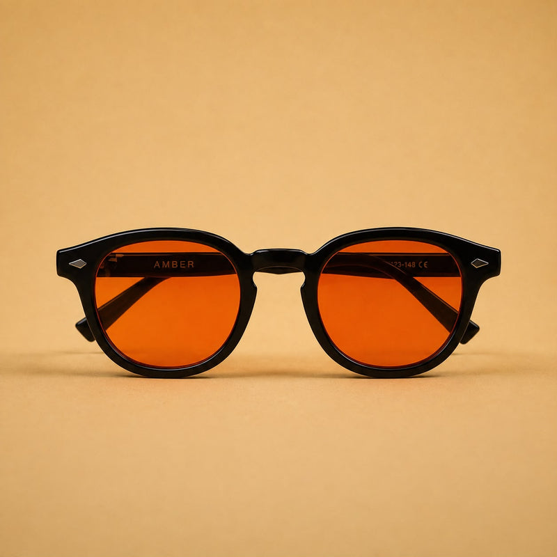 Óculos de bloqueio de luz azul Vanta modelo Amber, vistos de frente. Armação preta com lentes cor de laranja premium para uso no computador.
